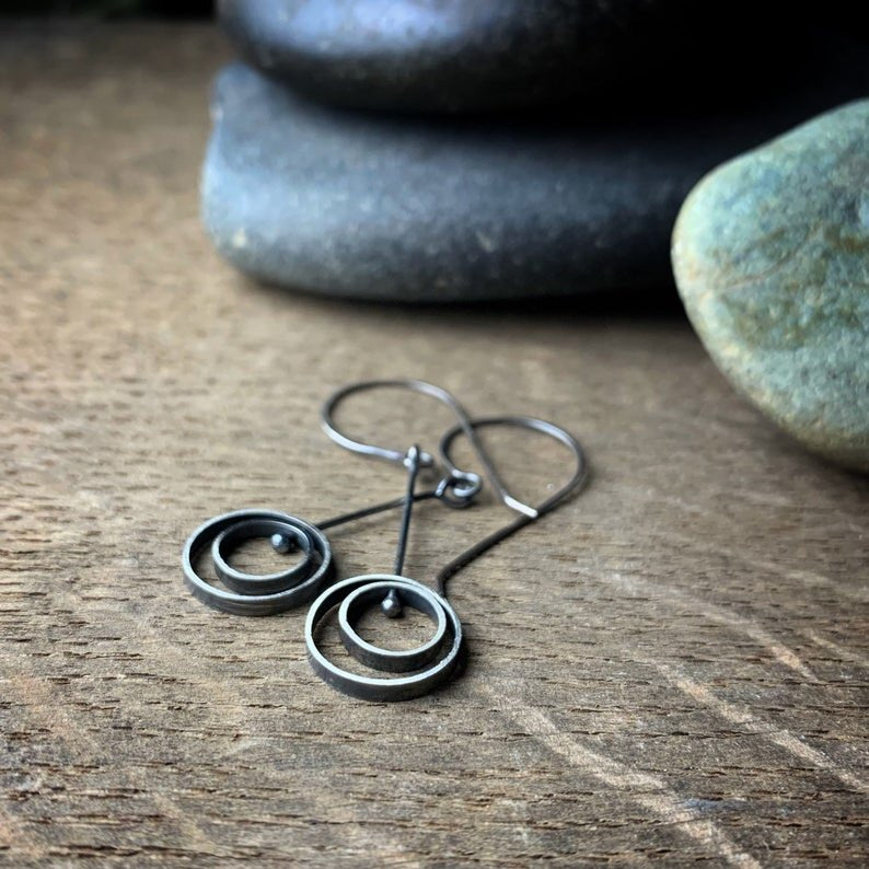 Pair of oxidized sterling silver kinetic dangle earrings with concentric circles