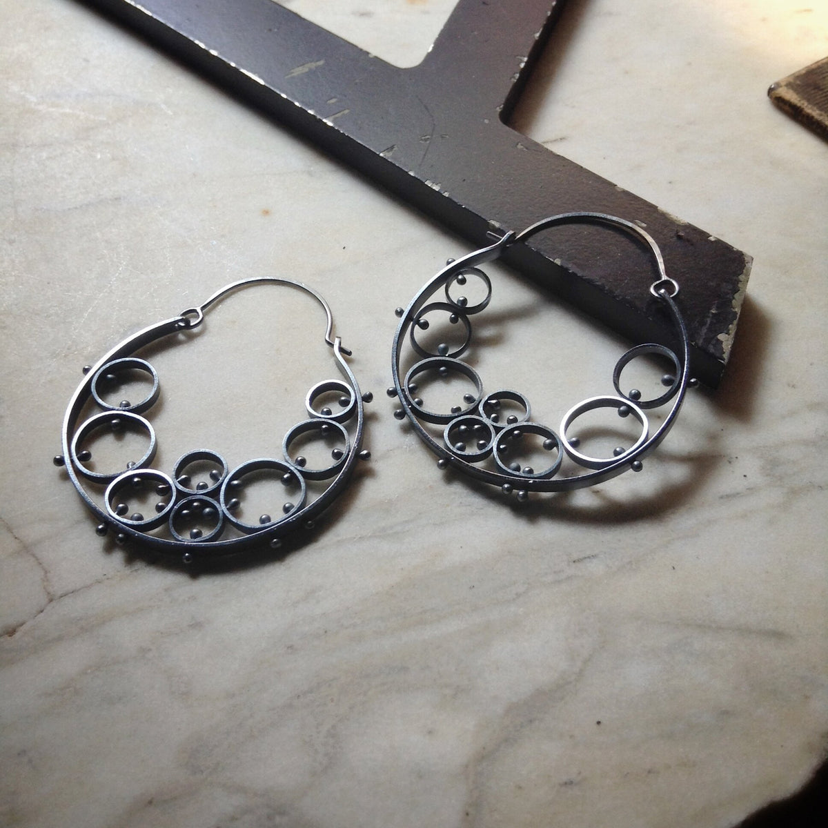 oxidized sterling silver hoop earrings made of many circular cells riveted together