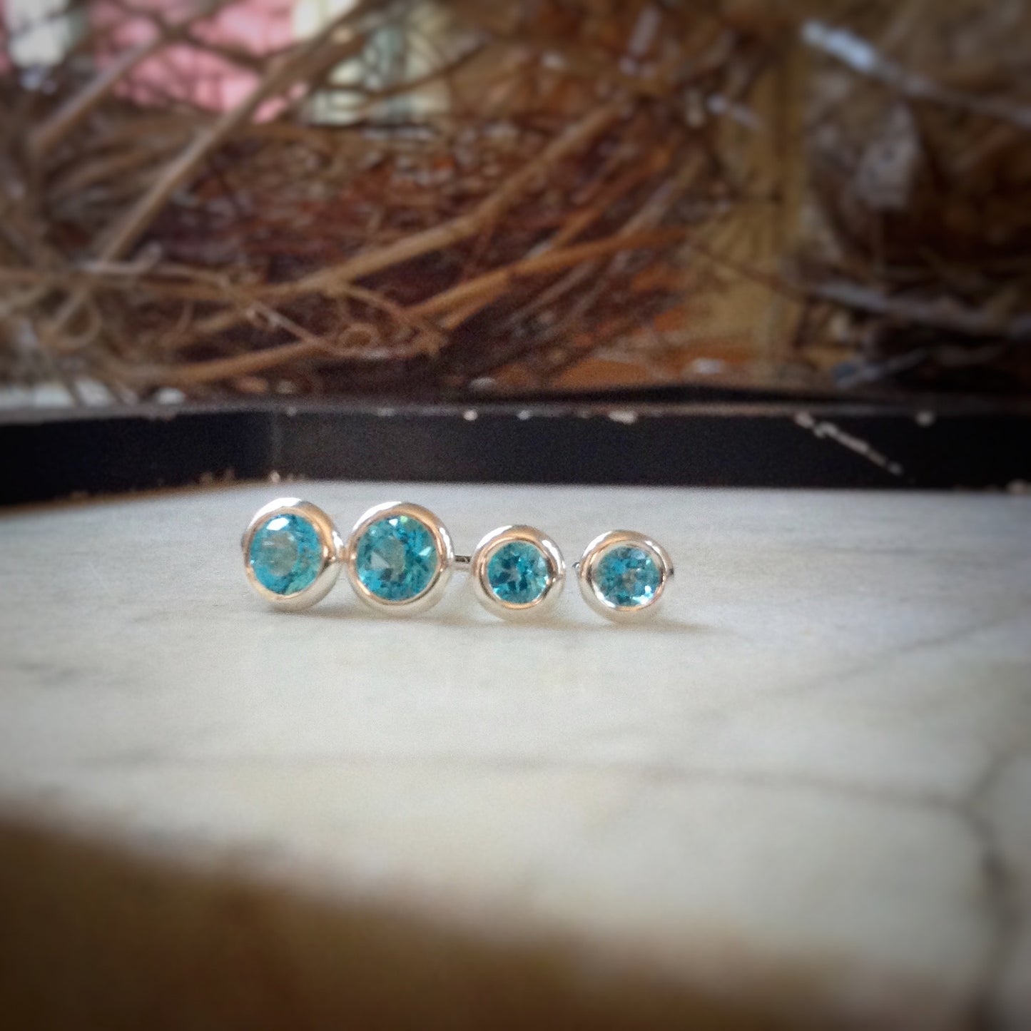 two sizes of bright blue topaz set in sterling silver bezels