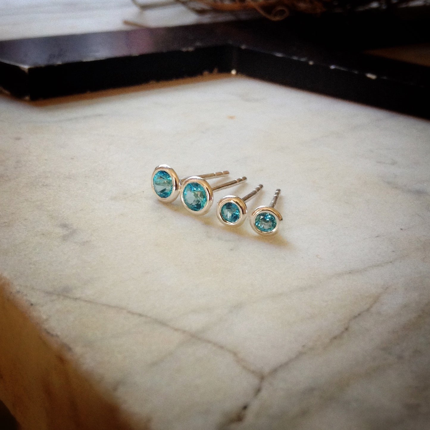 two sizes of bright blue topaz set in sterling silver bezels