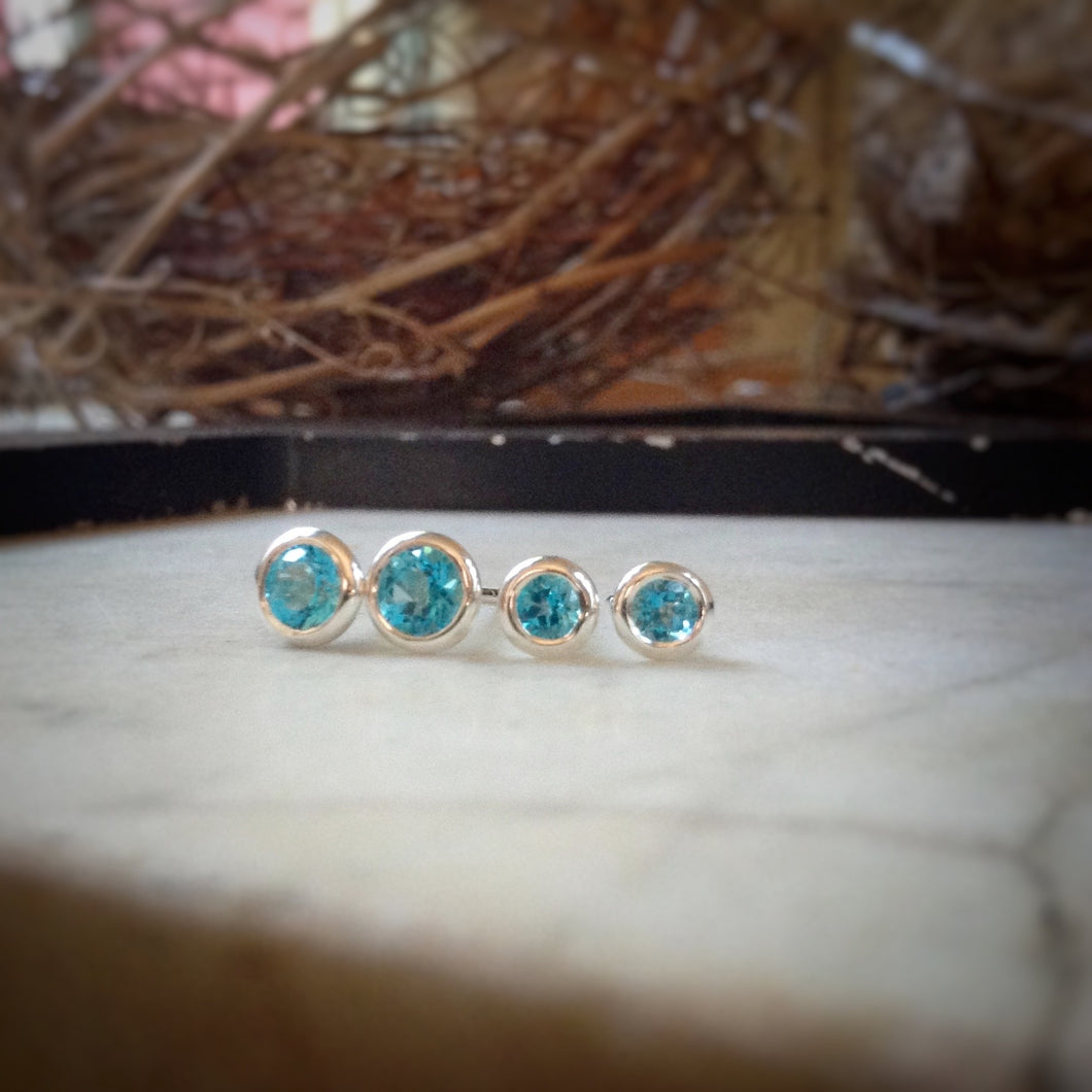two sizes of bright blue topaz set in sterling silver bezels