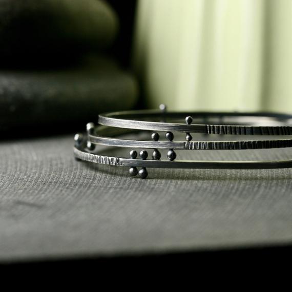 a stack of bracelets showing the detail of the rivets and texture