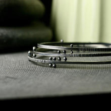 Load image into Gallery viewer, a stack of bracelets showing the detail of the rivets and texture
