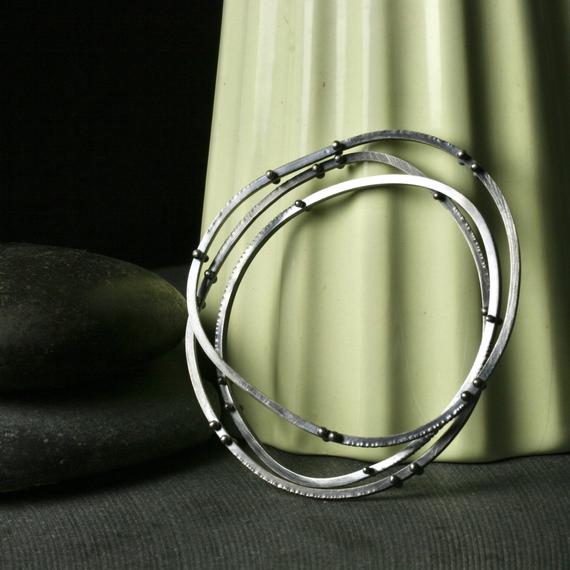 three asymmetrical bangle bracelets with rivets and texture