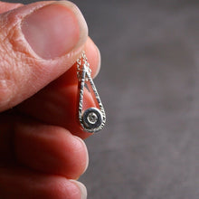 Load image into Gallery viewer, Sterling silver teardrop shaped pendant with a small diamond shown being held in a hand for scale
