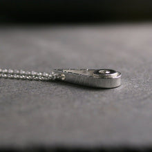 Load image into Gallery viewer, Sterling silver teardrop shaped pendant with a small diamond shown from the side to show thickness
