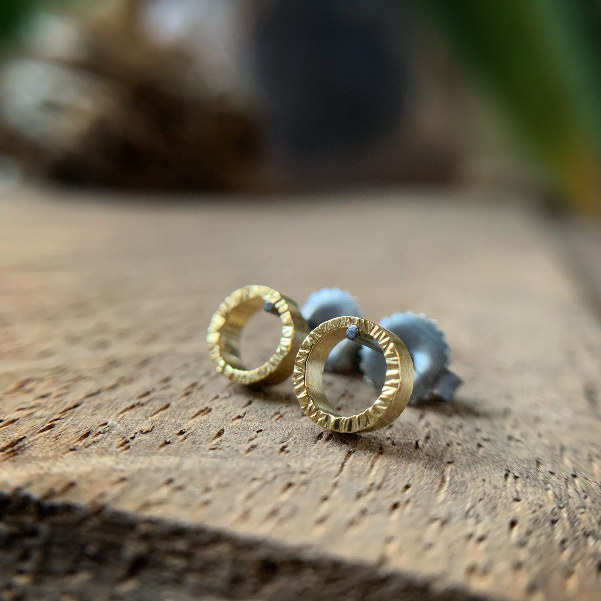 quarter inch yellow gold circles with hammered texture and oxidized silver posts and backs